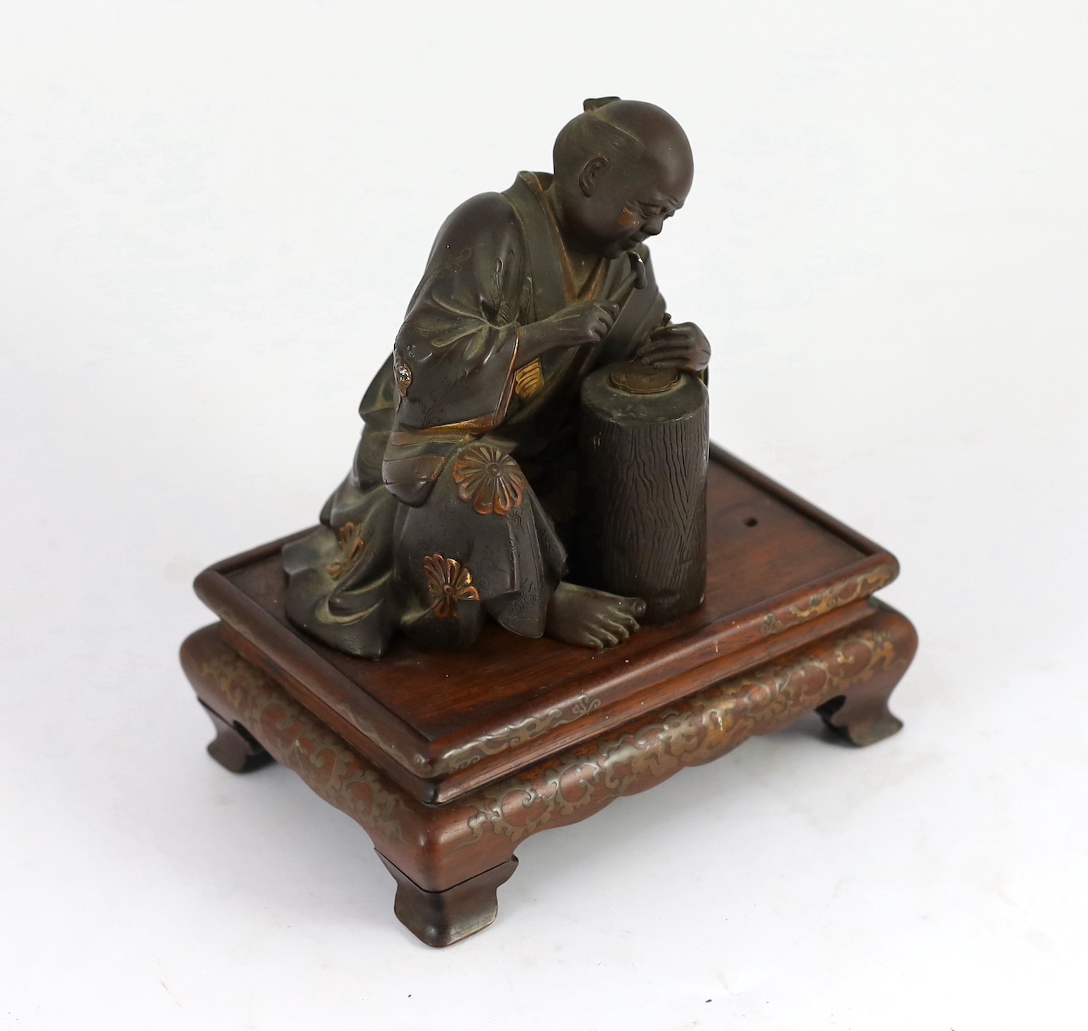 A Japanese bronze model of a sword fittings master craftsman, by Miyao Eisuke, Meiji period, total height 18cm including original gilt lacquered wood stand, small section of bronze lacking